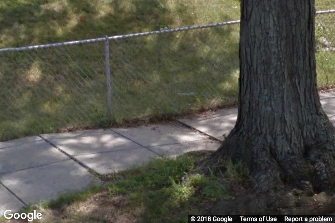 A Street View image of a sidewalk with a small elevation change